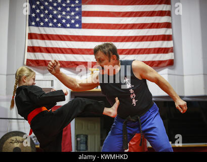 Moline, Iowa, USA. 28 Dez, 2016. Kung-Fu Lehrer John Morrow Holme mit Zade Allmon, 8, von LeClaire in seinem Studio in Moline am Mittwoch, 28. Dezember 2016. Morgen ist im Guinness Buch der Rekorde für den Abschluss 123 Liegestütze in einer Minute und sieht zu tun 1.000 pushups, 1000 Bein, und 1.000 Sit-ups in einer Stunde am kommenden Freitag auf seinem 65. Geburtstag. Credit: Andy Abeyta/Viererkabel - Zeiten/ZUMA Draht/Alamy leben Nachrichten Stockfoto