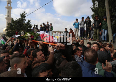 Ramallah Ramallah Stadt. Am 4. Januar, 2018. Trauernde tragen die Körper der Palästinensischen Musab At-Tamimi, 17, der bei Auseinandersetzungen mit israelischen Soldaten erschossen wurde, während der Trauerfeier in der West Bank Deir Netham Dorf, nördlich von Ramallah city, Jan. 4, 2018. Credit: Fadi Arouri/Xinhua/Alamy leben Nachrichten Stockfoto
