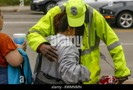 Davenport, Iowa, USA. 26. Okt 2016. Crossing Guard Bernard Harris Wünsche ein Kursteilnehmer einen sicheren und lustigen Halloween Wochenende mit einer Umarmung an der Kreuzung der Östlichen Allee und die Locust Street von Washington Volksschule in Davenport am Mittwoch, 26. Oktober 2016. Harris hat an der gleichen Kreuzung für 14 Jahre, Morgens und Nachmittags arbeitete trotz der zahlreichen medizinischen Fragestellungen. Credit: Andy Abeyta/Viererkabel - Zeiten/ZUMA Draht/Alamy leben Nachrichten Stockfoto