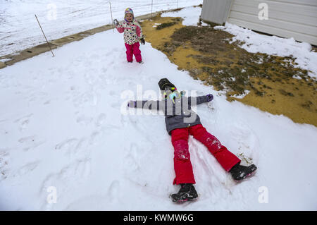 Davenport, Iowa, USA. 13 Mär, 2017. Morgan Toft, 3, wirft einen Schneeball, während ihre Schwester sich nähert, Allison, 7, macht ein Schnee Engel nach dem Reiten Motorschlitten auf Ackerland in Dixon am Montag, 13. März 2017. Ein paar Scott County Sno-Seekers Mitglieder zusammen, um für das, was die letzte Fahrt von einer spärlichen Schnee Saison werden könnte. Davenport erhalten nur über fünf Zentimeter Schnee über Nacht und den ganzen Tag Montag, einen kleinen Betrag für die Sno-Seekers, aber genug für das Letzte Hurra. Credit: Andy Abeyta/Viererkabel - Zeiten/ZUMA Draht/Alamy leben Nachrichten Stockfoto