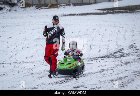 Davenport, Iowa, USA. 13 Mär, 2017. Vizepräsident der Scott County Sno-Seekers Kevin Toft läuft neben Tochter, Morgan, 3, wie sie reitet ein kleines Kind snowmobile in Dixon am Montag, 13. März 2017. Ein paar Scott County Sno-Seekers Mitglieder zusammen, um für das, was die letzte Fahrt von einer spärlichen Schnee Saison werden könnte. Davenport erhalten nur über fünf Zentimeter Schnee über Nacht und den ganzen Tag Montag, einen kleinen Betrag für die Sno-Seekers, aber genug für das Letzte Hurra. Credit: Andy Abeyta/Viererkabel - Zeiten/ZUMA Draht/Alamy leben Nachrichten Stockfoto