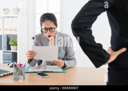 Junge attraktive Büro Frau erhalten gefeuert Gefühl schockiert, als sie Schreiben von Ihrem Chef erhalten und bei Entlassung Nachricht. Stockfoto