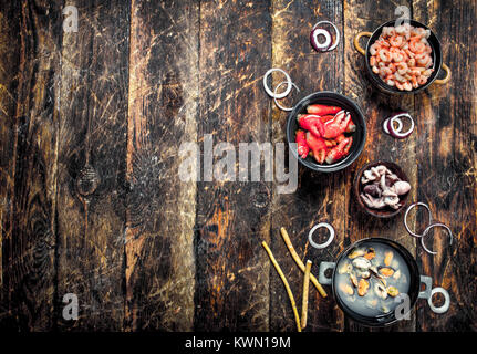 Fisch und Meeresfrüchte in Schalen. Auf einer hölzernen Hintergrund. Stockfoto