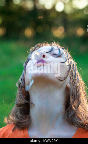 Wet Boy herum täuschen mit der Wasserpistole bespritzen. Stockfoto