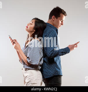 Porträt eines jungen Paares mit Smartphones Texting. Stockfoto