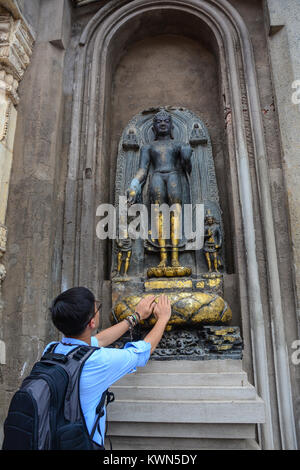 Ein junger Mann an Mahabodhi Tempel in Bodh Gaya, Indien zu beten. Stockfoto