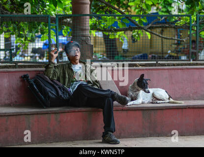 Bodhgaya, Indien - Jul 9, 2015. Ein Mann sitzt und das Rauchen im Park in Bodhgaya, Indien. Bodh Gaya, gilt als eines der wichtigsten buddhistischen pilgri Stockfoto