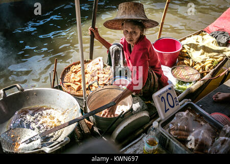 Thai Frau braten und Verkauf von zerschlagenen Bananen aus dem Boot auf dem Fluss Damnoen Saduk schwimmenden Markt, Thailand. Stockfoto