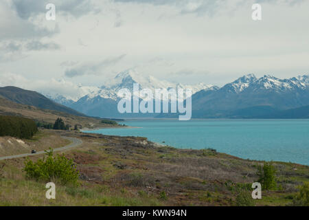 Iconic Mount Cook/Aoraki, Schnee mit Mount Cook Straße bedeckte und anschaulich Blue Lake Pukaki im Vordergrund. Sonnig, blauer Himmel. Frühling/Anfang Sommer. Stockfoto