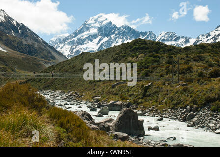 Iconic Mount Cook/Aoraki, schneebedeckte, mit Hooker Fluss und Brücke im Vordergrund. Sonnig, blauer Himmel. Frühling/Anfang Sommer. Stockfoto