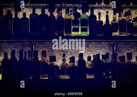 KHARKOV, UKRAINE - 25. OKTOBER 2017: Silhouetten von Flaschen mit Alkohol Tempel von Schuld auf einem Regal in einem Nachtclub bar. Stockfoto