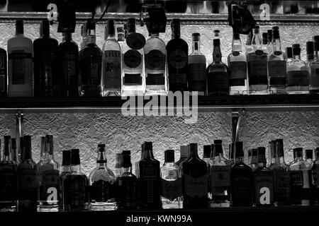 KHARKOV, UKRAINE - 25. OKTOBER 2017: Silhouetten von Flaschen mit Alkohol Tempel von Schuld auf einem Regal in einem Nachtclub bar. Stockfoto