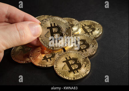Haufen bitcoins mit einem bitcoin Münze in der Hand Stockfoto
