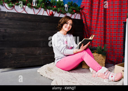 Mädchen tragen im Winter Pullover bei Zimmer mit Weihnachten Dekorationen. Stockfoto