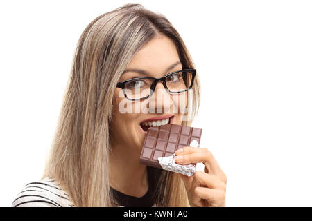 Junge Frau nimmt einen Bissen von einer Tafel Schokolade auf weißem Hintergrund Stockfoto