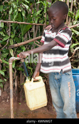 Ruandische Kind sammeln einen Behälter mit Wasser aus einem Standrohr. Stockfoto