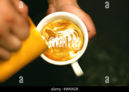 Tasse Kaffee. Latte Art Barista Focus in Milch und Kaffee gemacht. Vintage Farbe Stockfoto