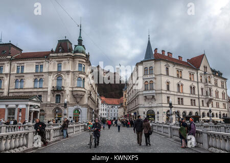 LJUBLJANA, Slowenien - 16 Dezember, 2017: Fußgänger überqueren der Brücke Tromostovje (Triple Bridge) von Presernov Square im mittelalterlichen Teil erreichen. Stockfoto