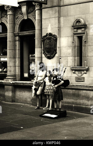 Junge dudelsackpfeifer Junge, mit einer Frau und Mädchen, Straßenmusik auf der Buchanan Street, Glasgow, Schottland Stockfoto