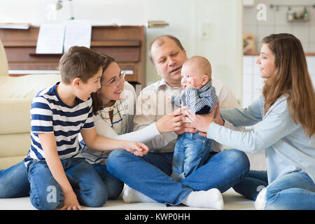 Porträt der jungen Familie mit drei süße Kinder Spaß zusammen zu Hause Stockfoto