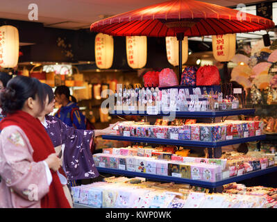 Japanische Frauen in kimonos auf einen Souvenirshop Display mit japanischen Splinte und Zubehör suchen. Matsubara Dori Street in der Nähe der Kiyomizu-dera. Higas Stockfoto