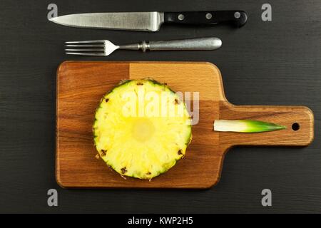 In Scheiben geschnittene Ananas auf dem Küchentisch. Diät essen. Vitamine gegen Grippe Stockfoto