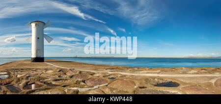 Panoramablick auf das Bild eines alten Leuchtturm in Swinemünde, einem Hafen in Polen an der Ostsee. Der Leuchtturm wurde als traditionelles Mühle entwickelt. Stockfoto