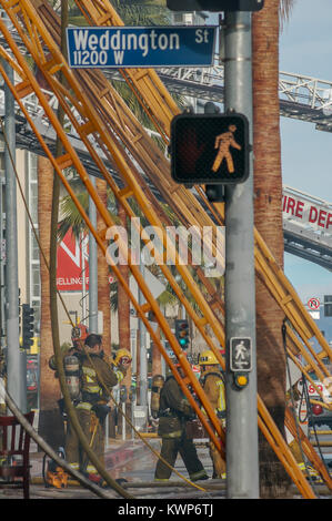 Los Angeles City Fire Department mit Holz Leitern in einem kommerziellen Gebäude Feuer. Stockfoto