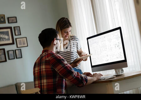 Junge attraktive Designer zusammen arbeiten von zu Hause aus Stockfoto