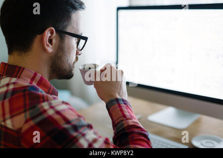 Junge schöne Designer, die am Projekt auf dem Computer