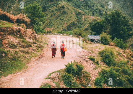 Zurück Blick auf zwei Mönche zu Fuß auf den Berg Straße in indischen Himalaya, Dharamsala, Baksu Stockfoto