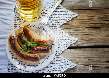 Gegrillte Würstchen mit Bier auf einer hölzernen Hintergrund. Selektiver Fokus Stockfoto