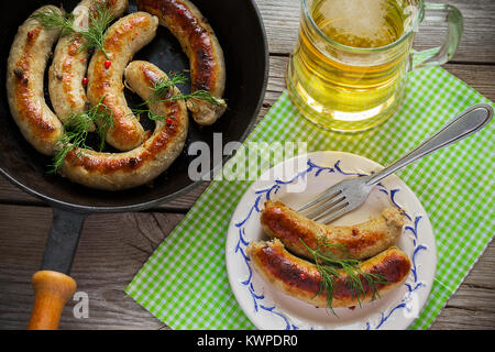 Gebratene Würstchen mit Gewürzen auf einer hölzernen Hintergrund Stockfoto