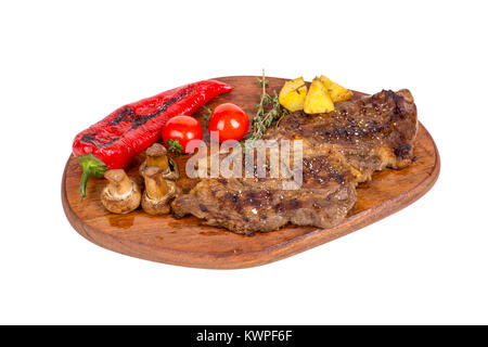 Detaillierte Ansicht von lecker lecker Gegrilltes Steak auf Holzplatte mit Kartoffel, Tomate und Paprika diente, auf weißem Hintergrund. Stockfoto