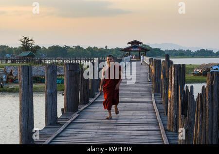 MANDALAY, MYANMAR - 3 Jan 2014: Ein buddhistischer Mönch Spaziergänge auf den U-Bein Brücke aus Teakholz bei Sonnenaufgang, in Mandalay, Myanmar. Stockfoto