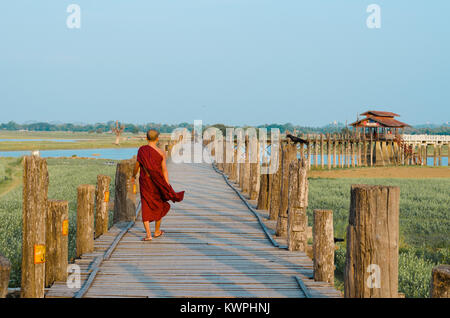 MANDALAY, MYANMAR - 3 Jan 2014: Ein buddhistischer Mönch Spaziergänge auf den U-Bein Brücke aus Teakholz bei Sonnenaufgang, in Mandalay, Myanmar. Stockfoto