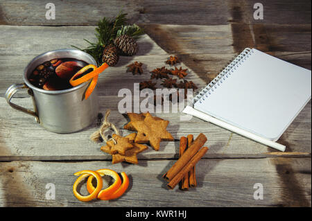 Traditionelle fruchtiger Glühwein aus dem alten Becher, auf einem alten Holztisch Stockfoto