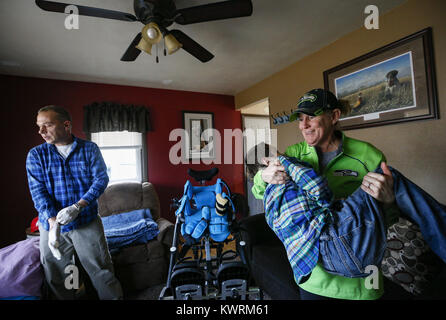 Davenport, Iowa, USA. 12. Januar 2017. Tina McDermott hebt Sohn, Ryan, 10, auf der Couch für Randy Cox, eine examinierte Krankenschwester mit Einheit Punkt Kinderheilkunde, der vier Jahre Arbeit mit Ryan zu Hause in Davenport McDermott auf Donnerstag, 12. Januar 2017 verbracht hat. McDermott war als Kleinkind mit Dravet-Syndrom, einer schweren Form von Epilepsie diagnostiziert und hat derzeit zwischen 10 und 20 Anfälle pro Tag. Eine Cannabis-Öl-Studie durch die Universität von Iowa funktionierte nicht für McDermott, aber er wird in Kürze eine Studie durch die Mayo-Klinik namens Fenfluramin Bewertung bei seltenen Epilepsie beginnen. (Kredit Im Stockfoto