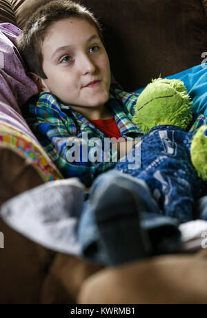 Davenport, Iowa, USA. 12. Januar 2017. Ryan McDermott, 10, sitzt mit seinem Grinch-Puppe in Seattle Seahawks Schlafanzug zu Hause in Davenport McDermott auf Donnerstag, 12. Januar 2017 gekleidet. McDermott war als Kleinkind mit Dravet-Syndrom, einer schweren Form von Epilepsie diagnostiziert und hat derzeit zwischen 10 und 20 Anfälle pro Tag. Eine Cannabis-Öl-Studie durch die Universität von Iowa funktionierte nicht für McDermott, aber er wird in Kürze eine Studie durch die Mayo-Klinik namens Fenfluramin Bewertung bei seltenen Epilepsie beginnen. Bildnachweis: Andy Abeyta/Quad-Stadt-Zeiten / ZUMA Draht/Alamy Live News Stockfoto