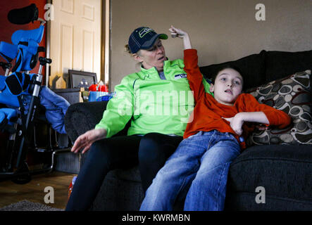 Davenport, Iowa, USA. 12. Januar 2017. Tina McDermott sitzt mit ihrem Sohn, Ryan, 10, als er einen kurzen Anfall in Davenport McDermott Zuhause auf Donnerstag, 12. Januar 2017 hat. McDermott war als Kleinkind mit Dravet-Syndrom, einer schweren Form von Epilepsie diagnostiziert und hat derzeit zwischen 10 und 20 Anfälle pro Tag. Eine Cannabis-Öl-Studie durch die Universität von Iowa funktionierte nicht für McDermott, aber er wird in Kürze eine Studie durch die Mayo-Klinik namens Fenfluramin Bewertung bei seltenen Epilepsie beginnen. Bildnachweis: Andy Abeyta/Quad-Stadt-Zeiten / ZUMA Draht/Alamy Live News Stockfoto