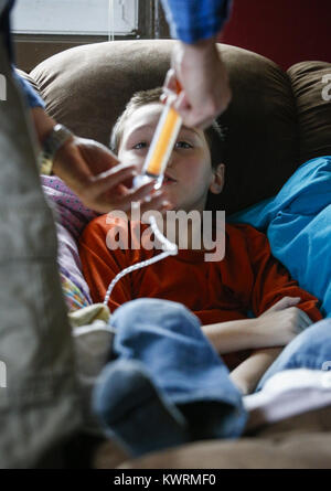 Davenport, Iowa, USA. 12. Januar 2017. Krankenschwester Randy Cox ernährt sich Ryan McDermott, 10 durch eine Magensonde zu Hause in Davenport auf Donnerstag, 12. Januar 2017 McDermott. McDermott war als Kleinkind mit Dravet-Syndrom, einer schweren Form von Epilepsie diagnostiziert und hat derzeit zwischen 10 und 20 Anfälle pro Tag. Eine Cannabis-Öl-Studie durch die Universität von Iowa funktionierte nicht für McDermott, aber er wird in Kürze eine Studie durch die Mayo-Klinik namens Fenfluramin Bewertung bei seltenen Epilepsie beginnen. Bildnachweis: Andy Abeyta/Quad-Stadt-Zeiten / ZUMA Draht/Alamy Live News Stockfoto