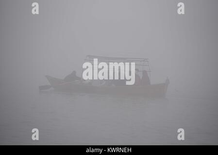 Allahabad, Uttar Pradesh, Indien. 5 Jan, 2018. Allahabad: Leute fahren mit dem Boot während eines kalten und nebligen Morgen im Sangam in Allahabad am 05-01-2018. Credit: Prabhat Kumar Verma/ZUMA Draht/Alamy leben Nachrichten Stockfoto