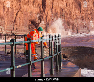 Honiton, Devon. 5 Jan, 2018. UK Wetter: Rat Arbeitnehmer versuchen zu fegen, der Tonnen von Schiefer und Kiesel, Sidmouth Esplanade in den Nachwehen des Sturms Eleanor abdecken. Credit: Foto Central/Alamy leben Nachrichten Stockfoto