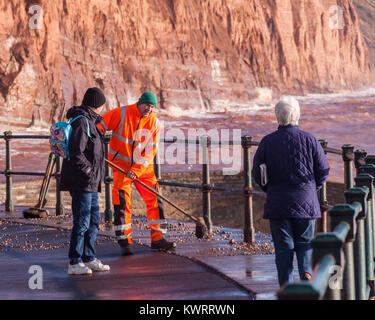 Honiton, Devon. 5 Jan, 2018. UK Wetter: Rat Arbeitnehmer versuchen zu fegen, der Tonnen von Schiefer und Kiesel, Sidmouth Esplanade in den Nachwehen des Sturms Eleanor abdecken. Credit: Foto Central/Alamy leben Nachrichten Stockfoto