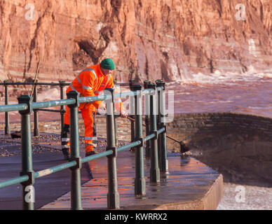 Honiton, Devon. 5 Jan, 2018. UK Wetter: Rat Arbeitnehmer versuchen zu fegen, der Tonnen von Schiefer und Kiesel, Sidmouth Esplanade in den Nachwehen des Sturms Eleanor abdecken. Credit: Foto Central/Alamy leben Nachrichten Stockfoto