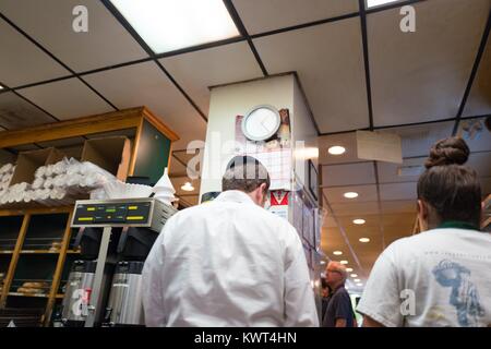 Mitarbeiter, darunter ein Mann, der eine Kippa (SKULLCAP), bereiten traditionelle Lebensmittel für die hohen jüdischen Feiertag von Rosch Haschana (Neujahr) Bei Izzy Brooklyn Bagels, einem Jüdischen kosher Deli und Bäckerei im Silicon Valley Town in Palo Alto, Kalifornien, 20. September 2017. Stockfoto