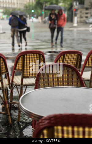 Frankreich, Paris, Paare Kreuzung Straße im Regen von einem Cafe gesehen. Stockfoto