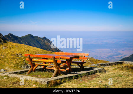 Holz Picknick Tische und Bänke auf dem Gipfel des Berges mit herrlichem Panoramablick auf Balea See in Sibiu, Rumänien Stockfoto