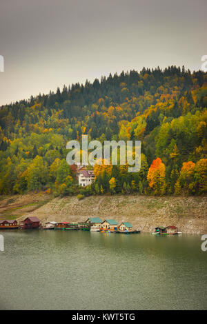 Herbst Landschaft mit der izvorul Muntelui See und bunten Wald und Häuser in Neamt, Rumänien Stockfoto