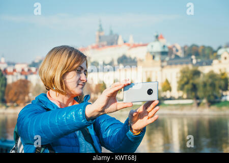 Frau eine selfie in Prag, Prager Burg und der St. Veits Dom im Hintergrund Stockfoto